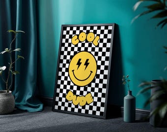May include: Black framed wall art featuring a yellow smiley face with lightning bolts and the words "COOL DUDE" in a bubble font against a black and white checkered background. The art is leaning against a teal wall.