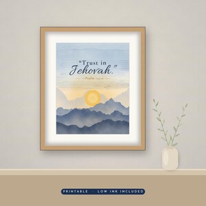 Op de afbeelding: Een ingelijste kunstdruk met een aquarellandschap van blauwe bergen onder een lichtgele zon en een zachte lucht. De tekst luidt Trust in Jehovah. Psalm 115:11. De print zit in een lichthouten lijst met een witte passe-partout rand.