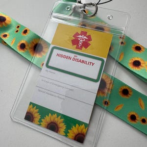 May include: A clear plastic ID holder with a green lanyard featuring a sunflower pattern. The ID card reads "MY HIDDEN DISABILITY" with space for personal information and a medical symbol.