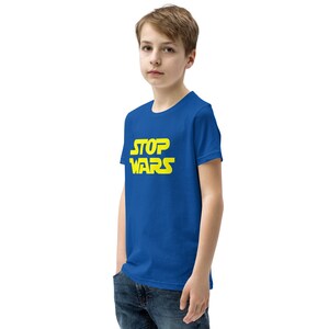 May include: A royal blue youth t-shirt with a yellow graphic that says "STOP WARS" in a stylized font.