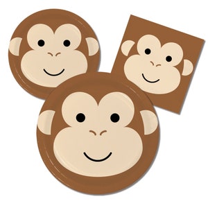 以下が含まれることがあります： サル顔のデザインが施された茶色の紙皿。皿は丸く、白い縁取りがあります。サル顔は茶色で、黒い目と白い鼻と口をしています。