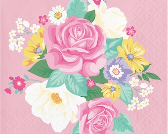 May include: A pink floral design with a bouquet of pink, white, and yellow flowers on a pink background. The flowers are surrounded by green leaves.