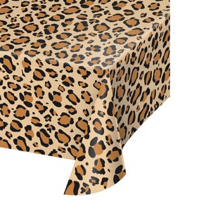 May include: A brown and black leopard print plastic tablecloth. The tablecloth is folded in the corner, showing the texture of the plastic.