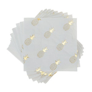 May include: A stack of white square paper napkins featuring a repeating gold pineapple pattern. The napkins are fanned out, displaying the design. Perfect for a tropical themed party or event.