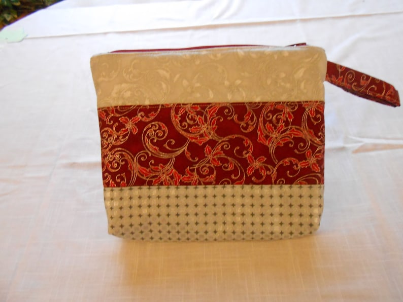 Pretty zipper pouches makes a nice gift for a lady Christmas colors of red or maroon with silver etching could use for evening pouch.