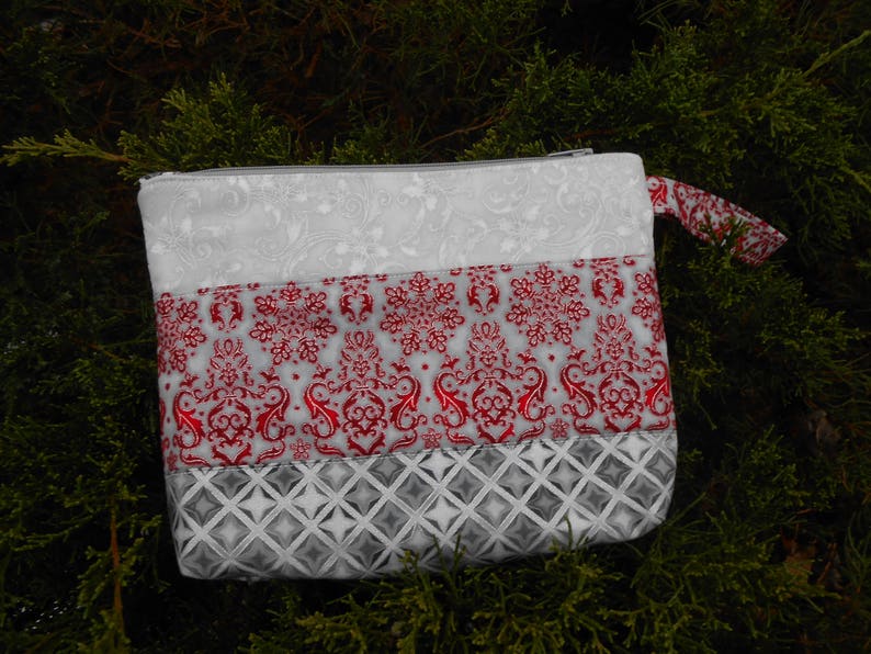 Pretty zipper pouches makes a nice gift for a lady Christmas colors of red or maroon with silver etching could use for evening pouch.