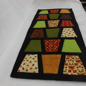 Tumbler table runner, the fall tumblers tremed in black makes a nice fall table topper, hand quilted. Black sashing