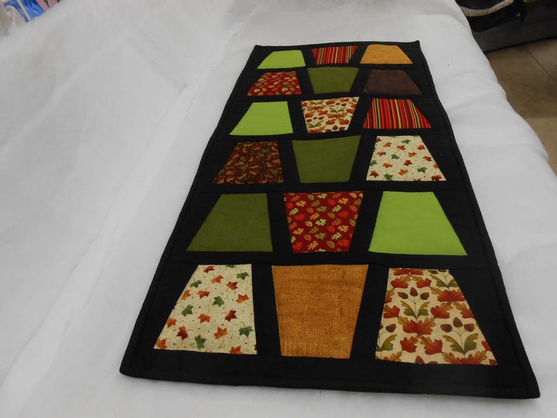 Tumbler table runner, the fall tumblers tremed in black makes a nice fall table topper, hand quilted. Black sashing