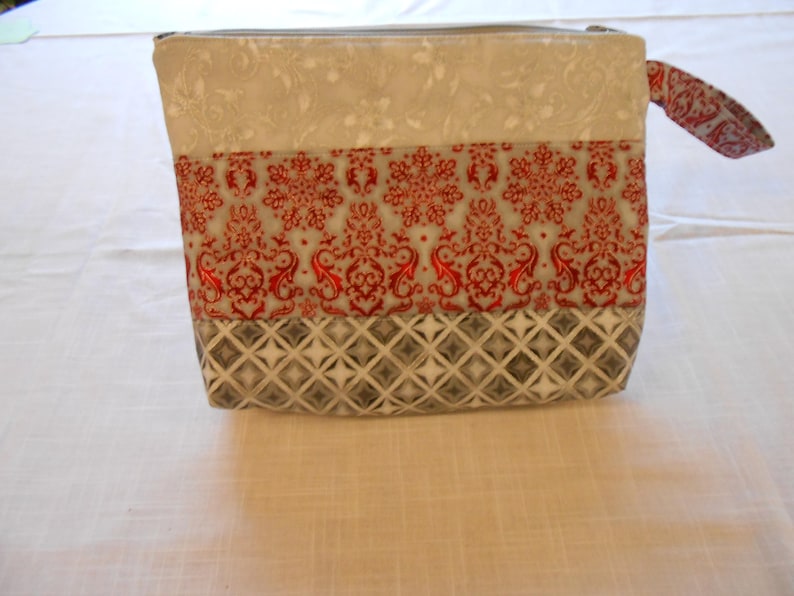 Pretty zipper pouches makes a nice gift for a lady Christmas colors of red or maroon with silver etching could use for evening pouch.