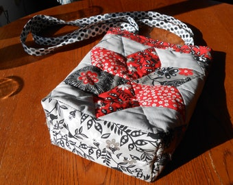 Red, black and white star handbag with over the shoulder handles, lined with a red print cotton fabric with pockets on one side.