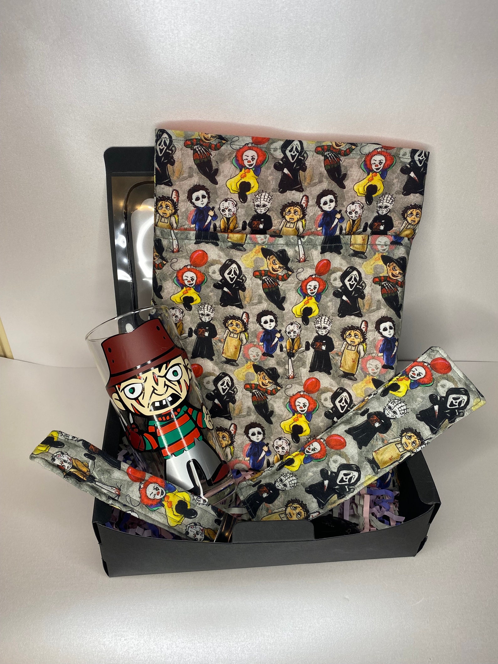 A bookish, horror hamper full of different items including a book mark, a book glass, book sleeve.