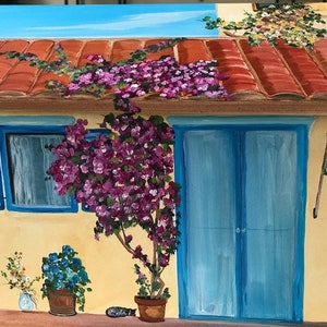 May include: A hand-painted wooden box with a yellow exterior, a red tiled roof, and a blue door. The box features a window with blue shutters, a potted plant with purple flowers, and a welcome flag.