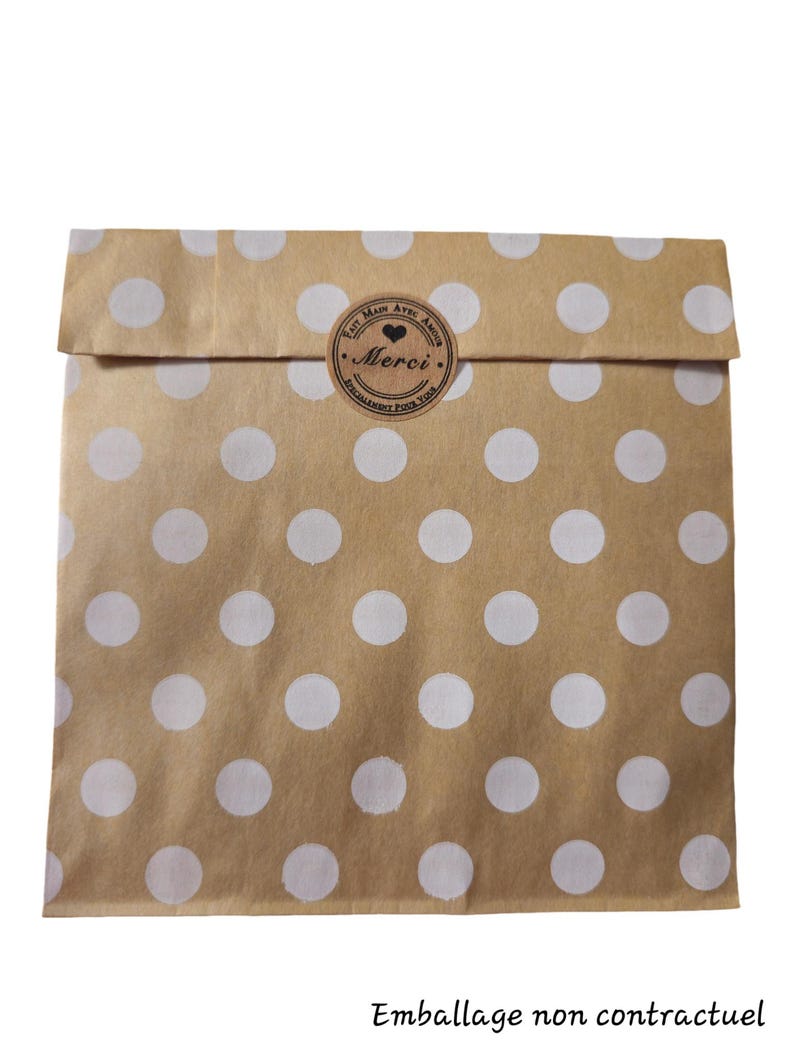 May include: A brown paper bag with white polka dots. The bag has a sticker that says "Fait Main Avec Amour" and "Merci" with a heart symbol.