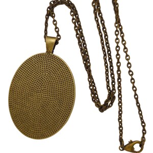 May include: A gold-toned chain necklace with a round pendant. The pendant has a textured surface and a smooth, polished edge.