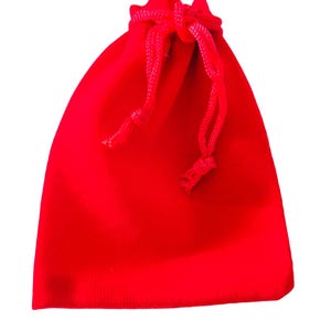 May include: A red velvet drawstring bag. The bag is empty and ready to be filled with a gift.