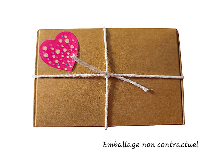 May include: A brown cardboard box tied with white twine and decorated with a pink heart sticker with white polka dots.