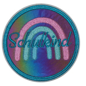 Könnte beinhalten: Ein runder, blauer und schimmernder Aufnäher mit einem Regenbogen-Design und dem Text "Schulkind" in einer kursivschrift.