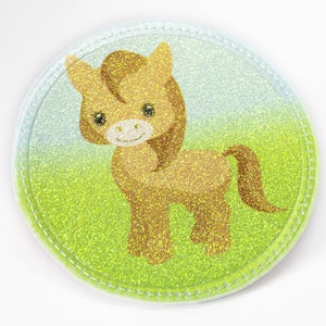 Könnte beinhalten: Ein braunes und weißes Pferd vor einem hellblauen Hintergrund. Das Pferd steht auf einem grünen Feld mit Glitzer.