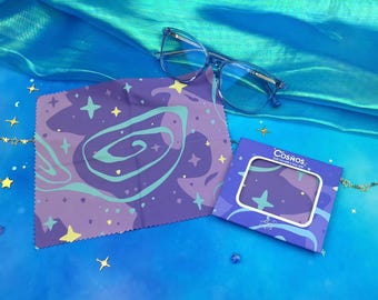 May include: A purple and blue microfiber cleaning cloth with a galaxy print and white stars. The cloth is packaged in a small cardboard box with the word "COSMOS" printed on it.