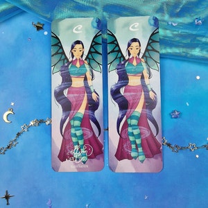 May include: Two colourful bookmarks featuring a cartoon illustration of a female character with blue hair, wings, and a pink and green outfit. The text "ellyon art" and "ILLUSTRATION" are printed on the bottom of the bookmarks.