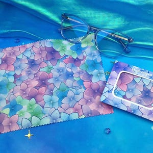 May include: A blue and purple floral microfiber cleaning cloth with a matching cardboard box. The box has the text "Hydrangea" printed on it.