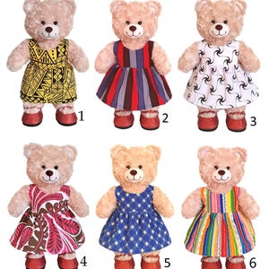 May include: Six plush teddy bears wearing different patterned dresses. The dresses are in various colours and patterns, including yellow, red, white, brown, blue, and rainbow.