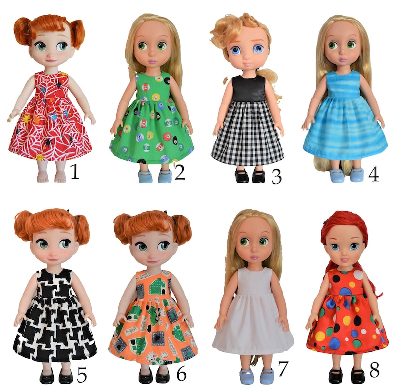 May include: Eight different doll dresses in various colors and patterns, including red, green, black, white, and blue. The dresses are all sleeveless and have a full skirt. The dolls are not included.