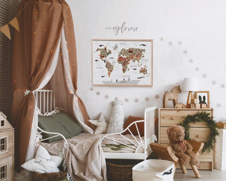 May include: A white bed frame with a brown canopy and a green blanket. A world map poster with the text "mini explorers" is hanging on the wall above the bed. The wall is decorated with beige star stickers.