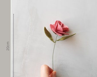 May include: A single pink felt flower with green felt leaves on a wire stem. The flower is approximately 20 cm long. Mini Flower Selection.
