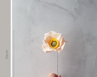 May include: A single, light pink felt poppy flower with a yellow center. The flower is on a wire stem and is approximately 20 cm long. Mini Flower Selection.