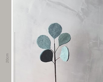 Könnte beinhalten: Ein Zweig mit Mini-Blumen aus Filz in Blautönen und Grün, 20 cm lang. Die Blumen sind auf einem dünnen braunen Stiel angeordnet.