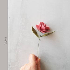 May include: A single pink felt flower with green felt leaves on a wire stem. The flower is approximately 20 cm long. Mini Flower Selection.