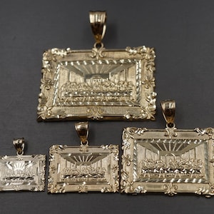 May include: Four gold-tone pendants featuring a detailed depiction of the Last Supper. The pendants are in different sizes and have ornate frames.