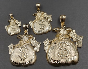 May include: Four gold-tone money bag pendants of varying sizes. Each pendant features a detailed design with a dollar sign in the center and a rope-like detail around the top. The pendants are perfect for adding a touch of luxury to any jewelry collection.