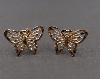 Puede incluir: Un par de pendientes de mariposa de oro con un diseño delicado e intrincado.