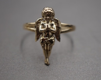 Pierścionek z obrączką przedstawiającą modlącego się anioła, wykonany z 10-karatowego żółtego złota, z diamentem o średnicy 0,7 cala i szlifem brylantowym.