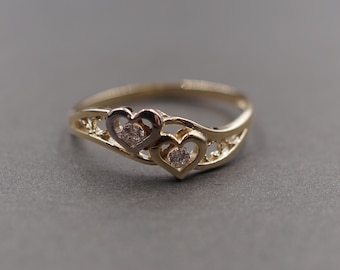Anillo delicado de doble corazón con circonita cúbica en dos tonos de oro amarillo macizo de 10 quilates.