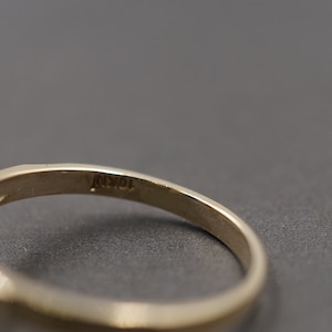 May include: Close-up of the inside of a gold ring with the inscription "10K" on the band.