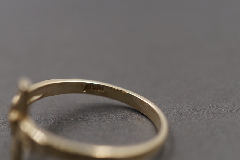 May include: Close-up of the inside of a gold ring with the inscription "10K" on the band.