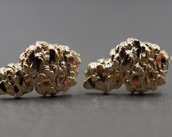 Könnte beinhalten: Ein Paar goldene Ohrringe mit einem strukturierten, diamantgeschliffenen Design. Die Ohrringe sind aus 10 Karat Gold gefertigt und haben eine polierte Oberfläche.