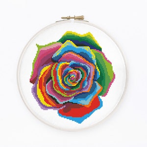 May include: A colorful rainbow rose cross stitch pattern in a white embroidery hoop.