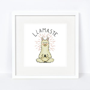 Op de afbeelding: Witte ingelijste print met een mediterende lama met de tekst "LLAMASTE" in zwart.