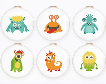 Op de afbeelding: Zes borduurringen met verschillende gepixelde monsterontwerpen. De monsters zijn groen, oranje en geel met verschillende kenmerken zoals hoorns, ogen en tanden.