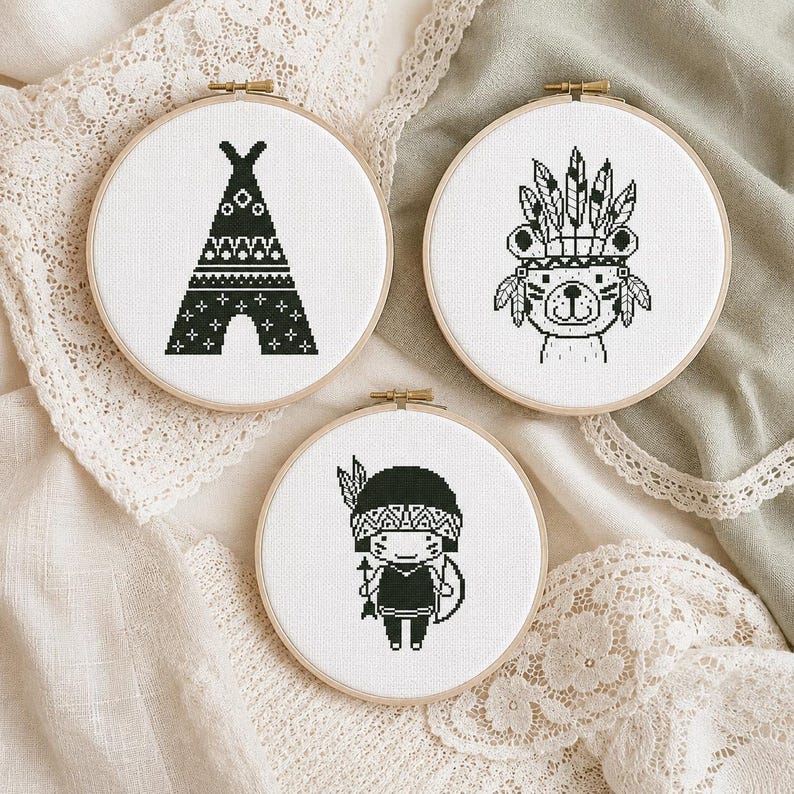 Boho nursery cross stitch pattern PDF set of 3 featuring a patterned teepee, a cute bear wearing a feather headdress, and a small child in tribal-style costume with bow and arrow, all in a bold monochrome black and white style. A striking stitching project for boho nursery crafters and adventure-themed kids' room enthusiasts. Digital instant download counted cross stitch chart.