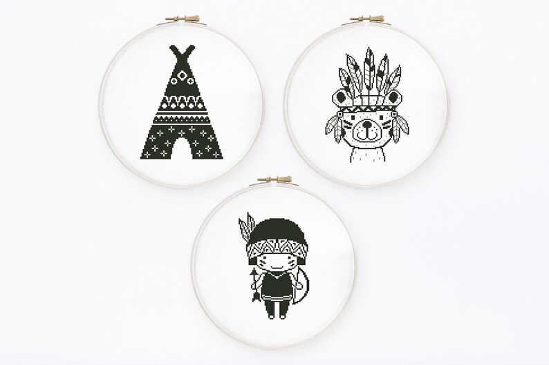 May include: Three black and white embroidery hoops with different designs. The first hoop features a teepee with geometric patterns. The second hoop features a bear wearing a headdress with feathers. The third hoop features a person wearing a headdress with feathers and holding a spear.