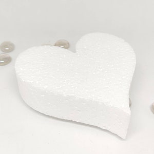 May include: A white foam heart shape, perfect for crafting projects. The heart is smooth and has a slightly textured surface.