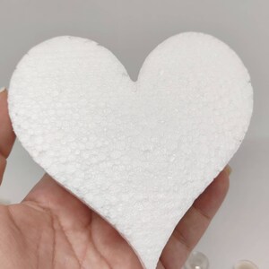 May include: A white foam heart shape, perfect for crafting projects. The heart is smooth and has a slightly textured surface.