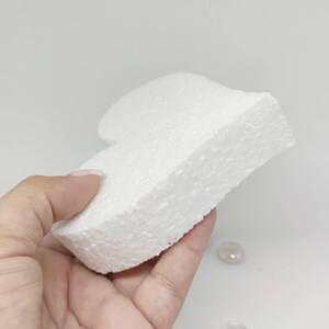 May include: A white styrofoam heart shape, perfect for crafting projects. The heart is smooth and has a slightly textured surface.