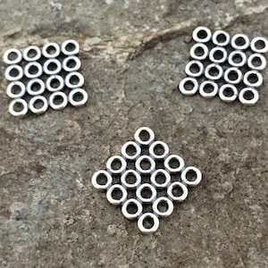 May include: Three silver metal squares with a grid pattern of small circles. Each square has 25 circles.