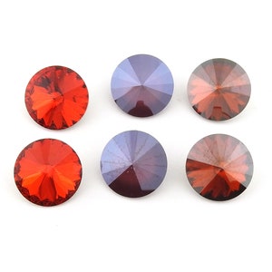 May include: Six round, faceted glass rhinestones. Three are red and three are purple.